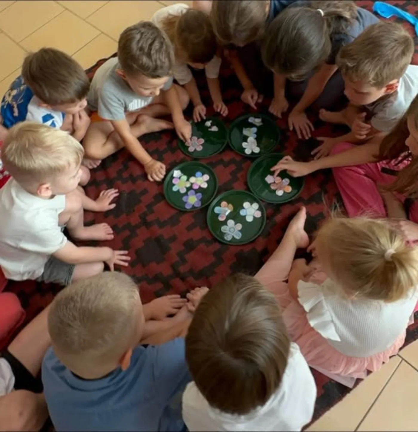 Copii așezați în cerc la un atelier Kairos