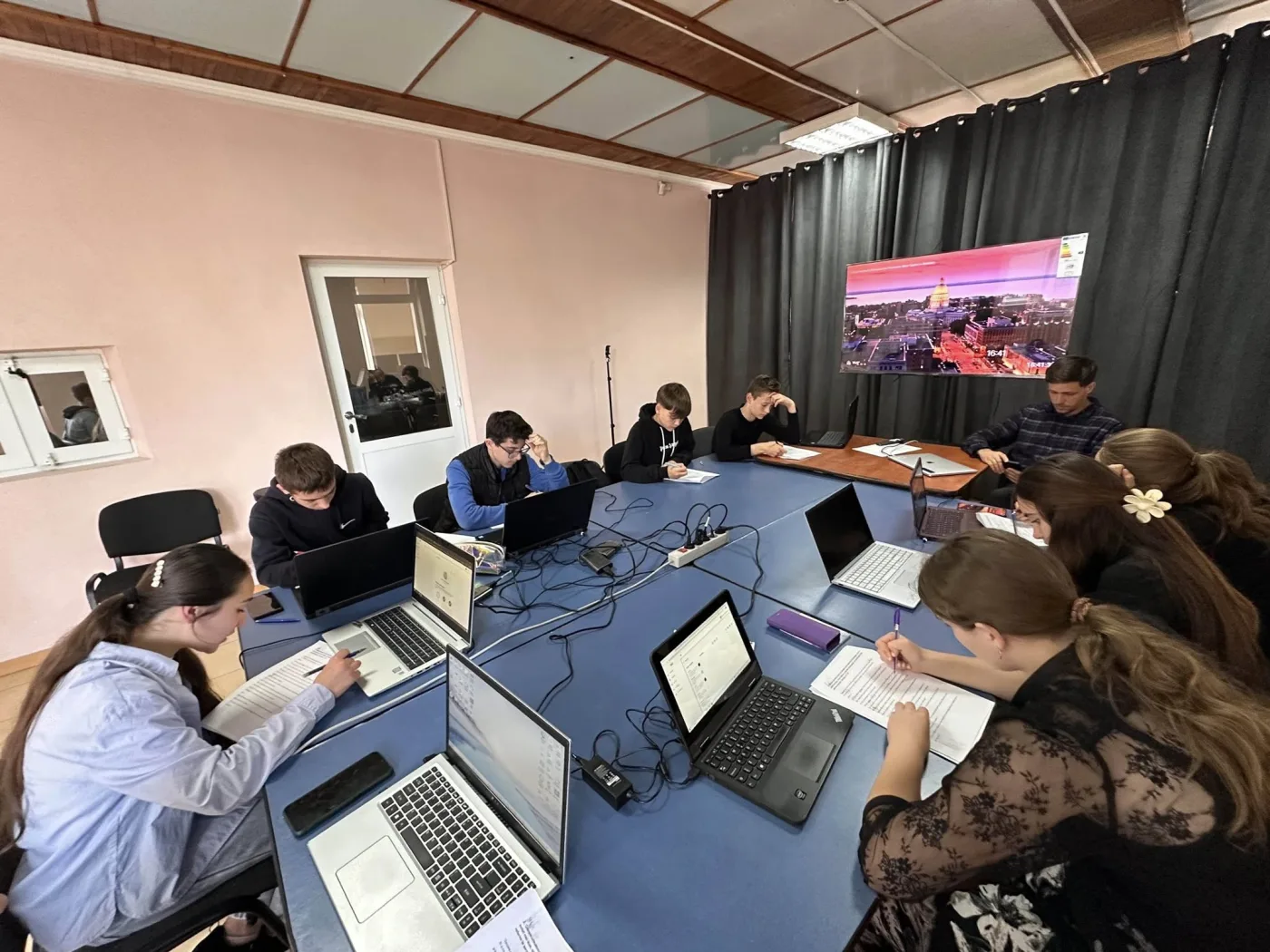 Adolescenți lucrând la laptopuri la cursul IT